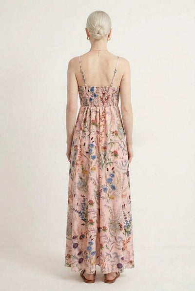 Woman wearing a rosewater pink floral print maxi dress with spaghetti straps