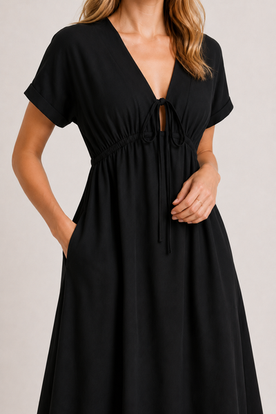 Model standing against a white studio background wearing the black onyx Sabine midi.